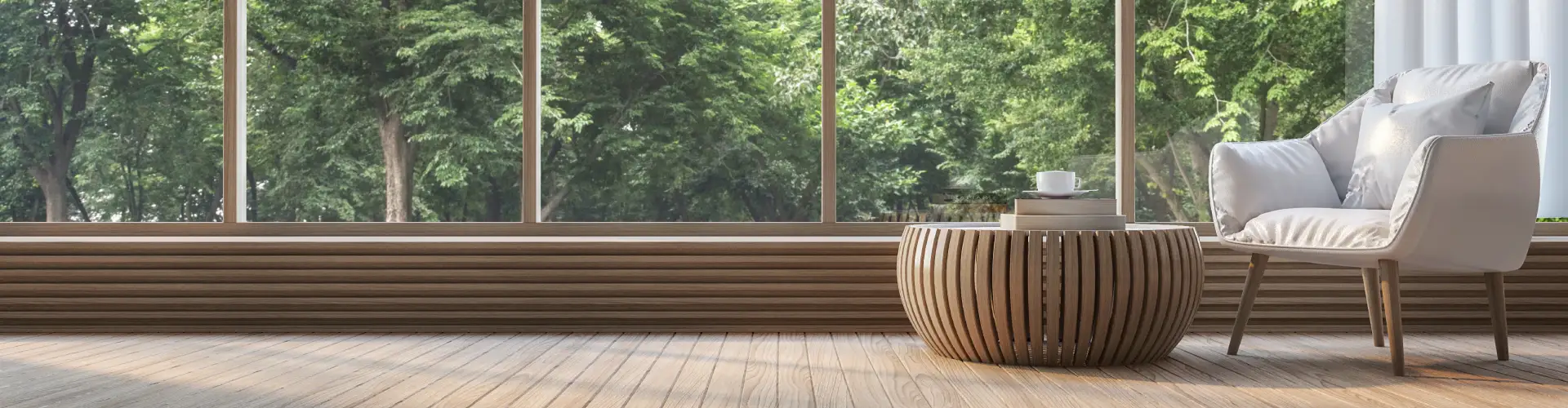 nterior moderno con silla blanca, mesa de café de madera y vista a árboles a través de grandes ventanales.