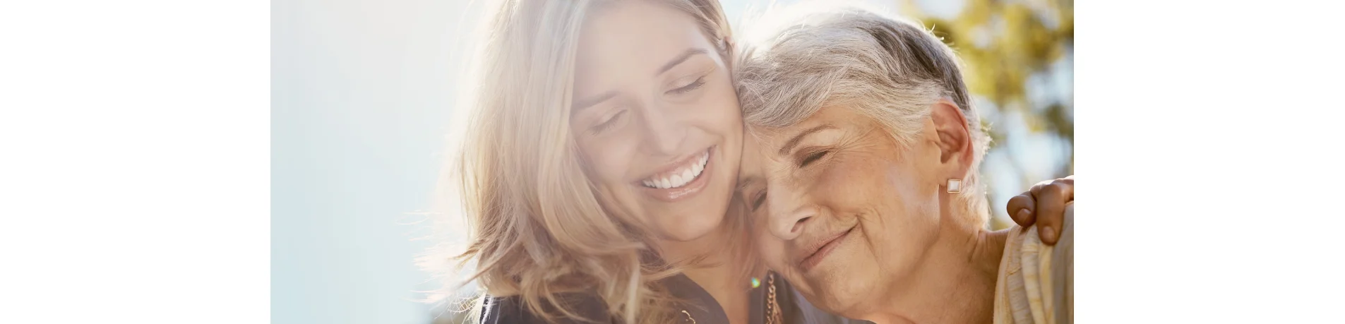 Persona joven abrazando a persona mayor en un entorno exterior con luz natural, concepto de apoyo familiar y cuidado en la jubilación