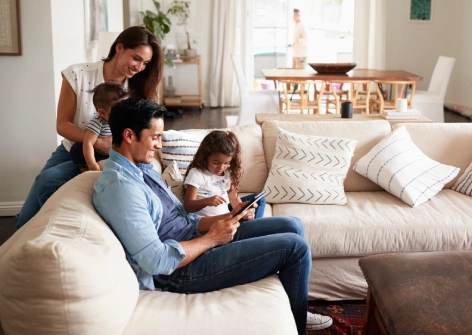 Familia sentada en el salón de su casa disfrutando de un momento juntos en un entorno luminoso y tranquilo